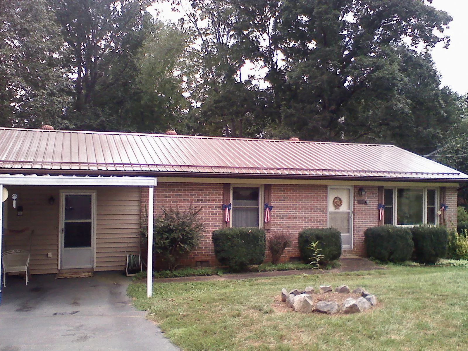Bronze metal roof and carport on a brick ranch home — Roof Repair work by our crew in Lynd